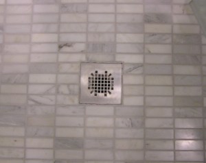 Shower floor tile is 1x2 marble tiles that look like minis of the floor tile.