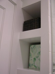 The cubbies hold a ton--I have an ugly plastic cleaning caddy on that middle shelf (look for that artwork in a later post!)